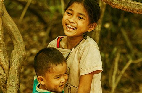 A young boy and girl smiling after being helped by a Volunteer