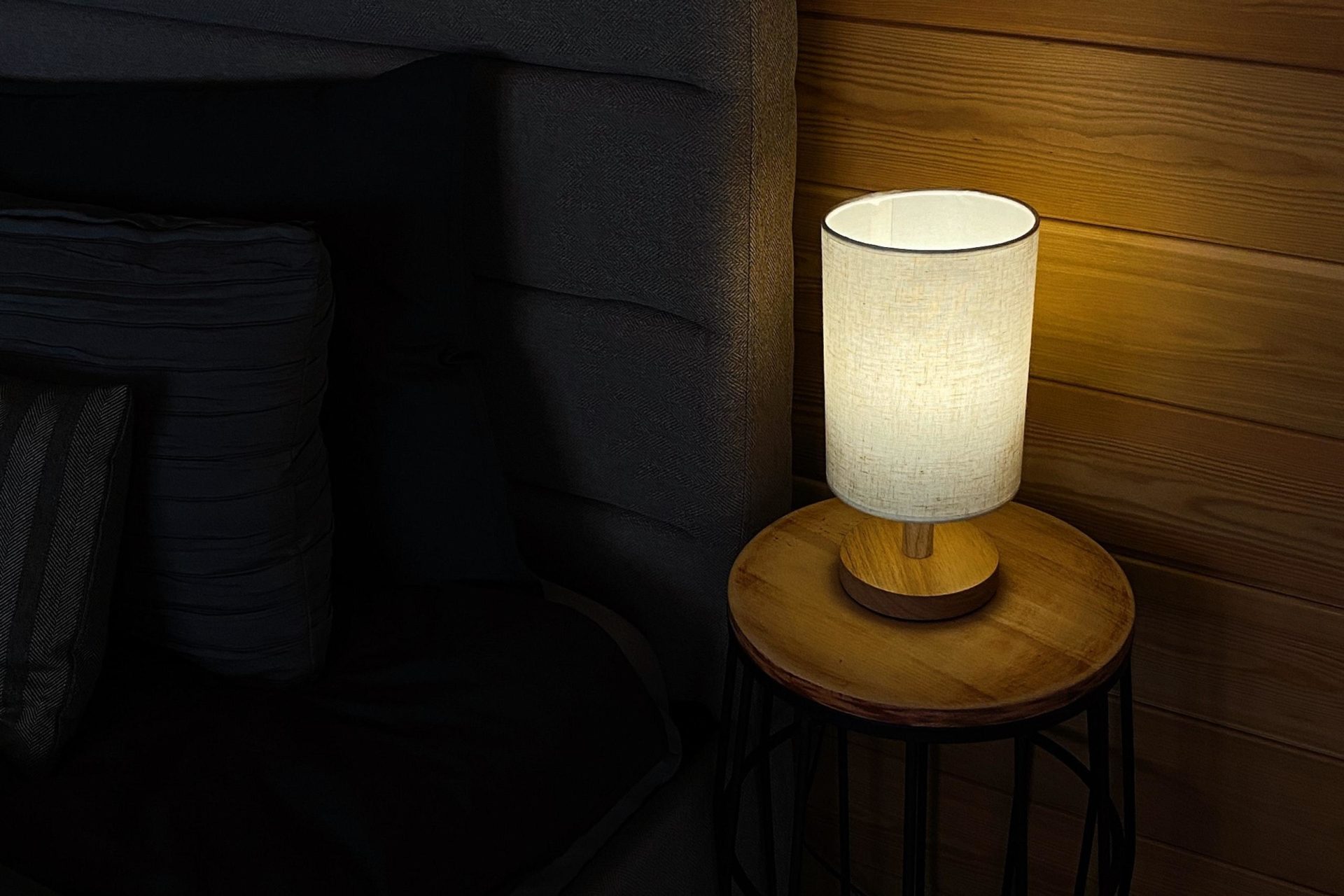 Lamp on bedside table in cozy dark room for somebody to Sleep in