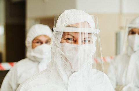 A Volunteer woman in a white hazmat suit