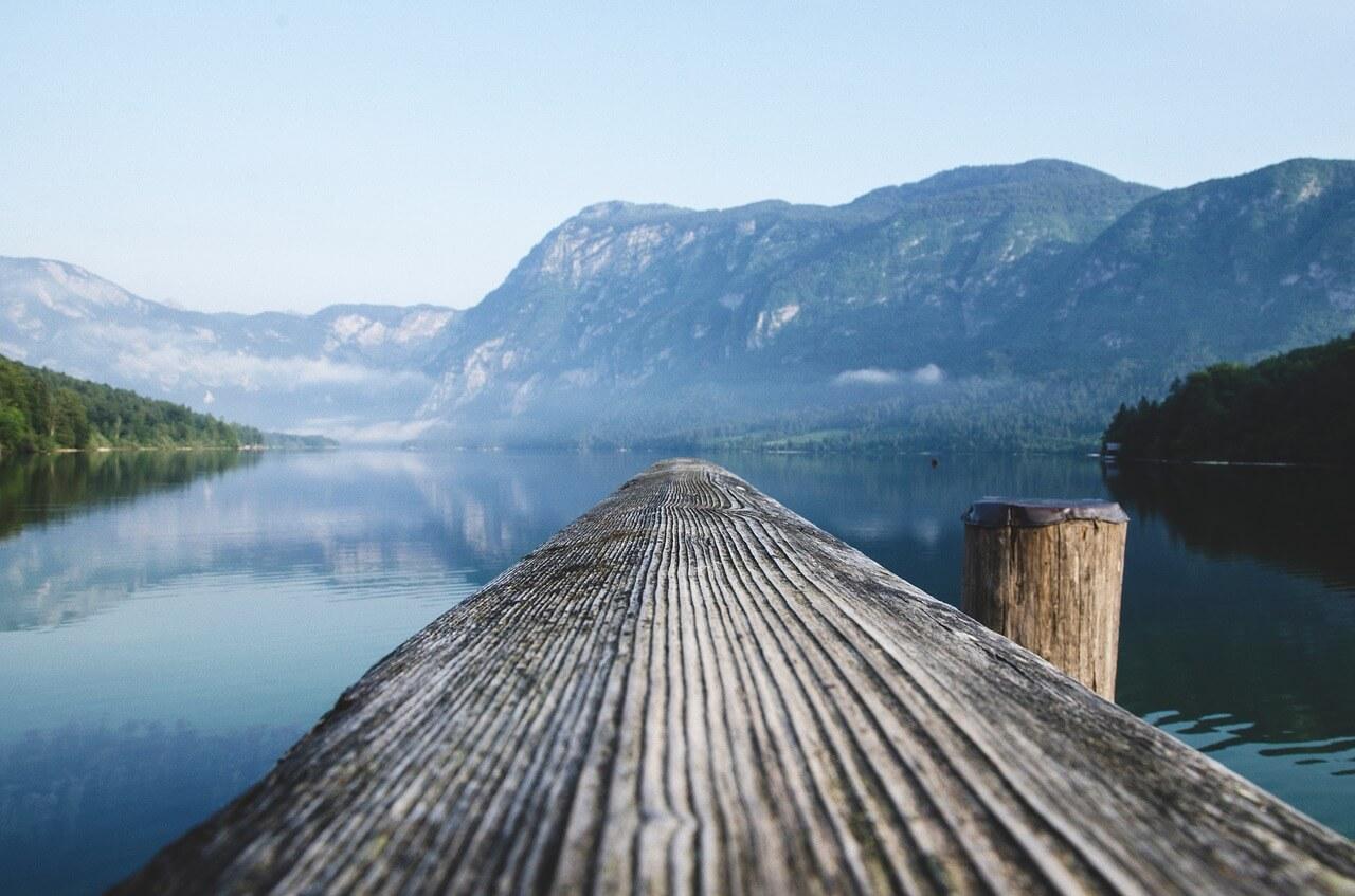 Boardwalk strectched out into a lake near mountains