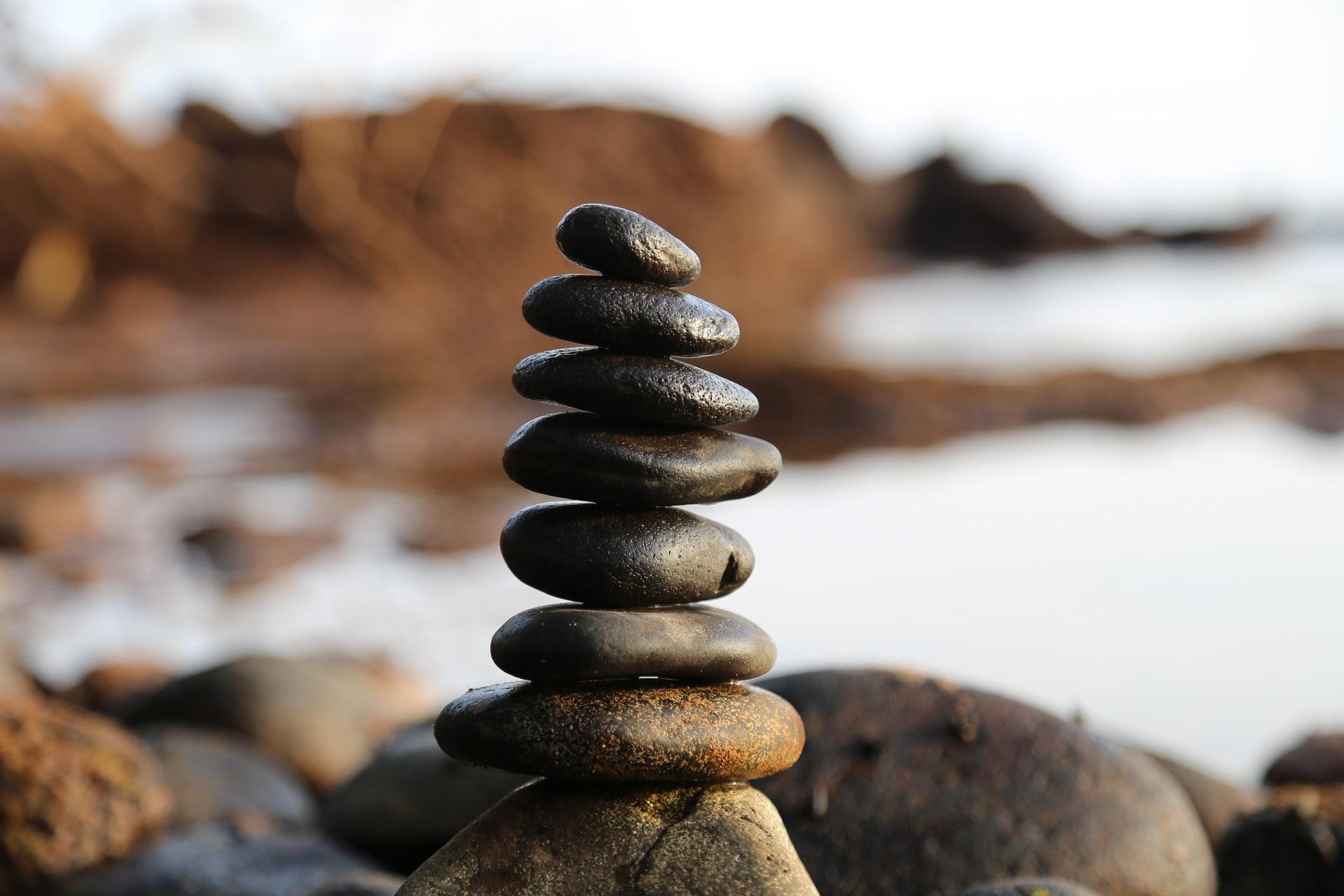 Pile of round stones stacked next to a lake