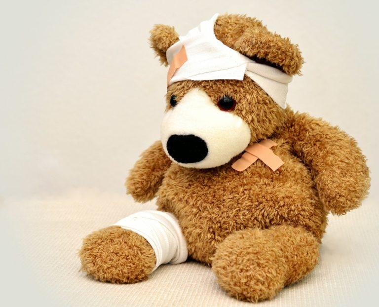 Teddy bandaged and plastered after a medical emergency abroad