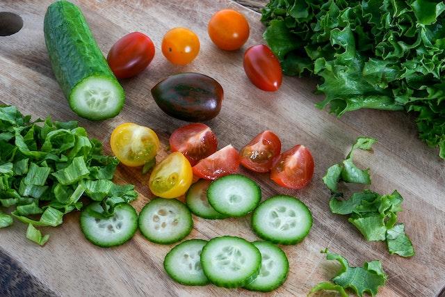 Side salad preparation of lettuce, cucumber and tomoatoes