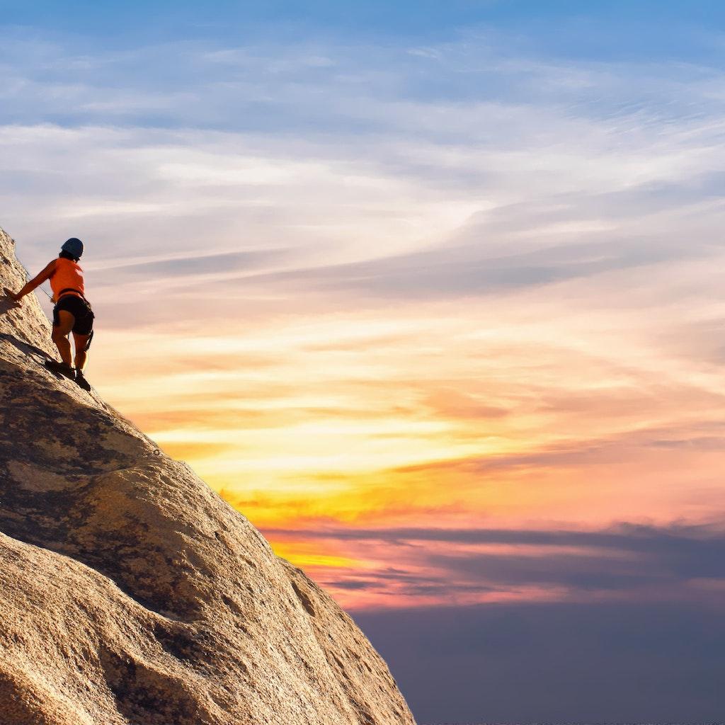 Person embracing the challenge of climbing a mountain