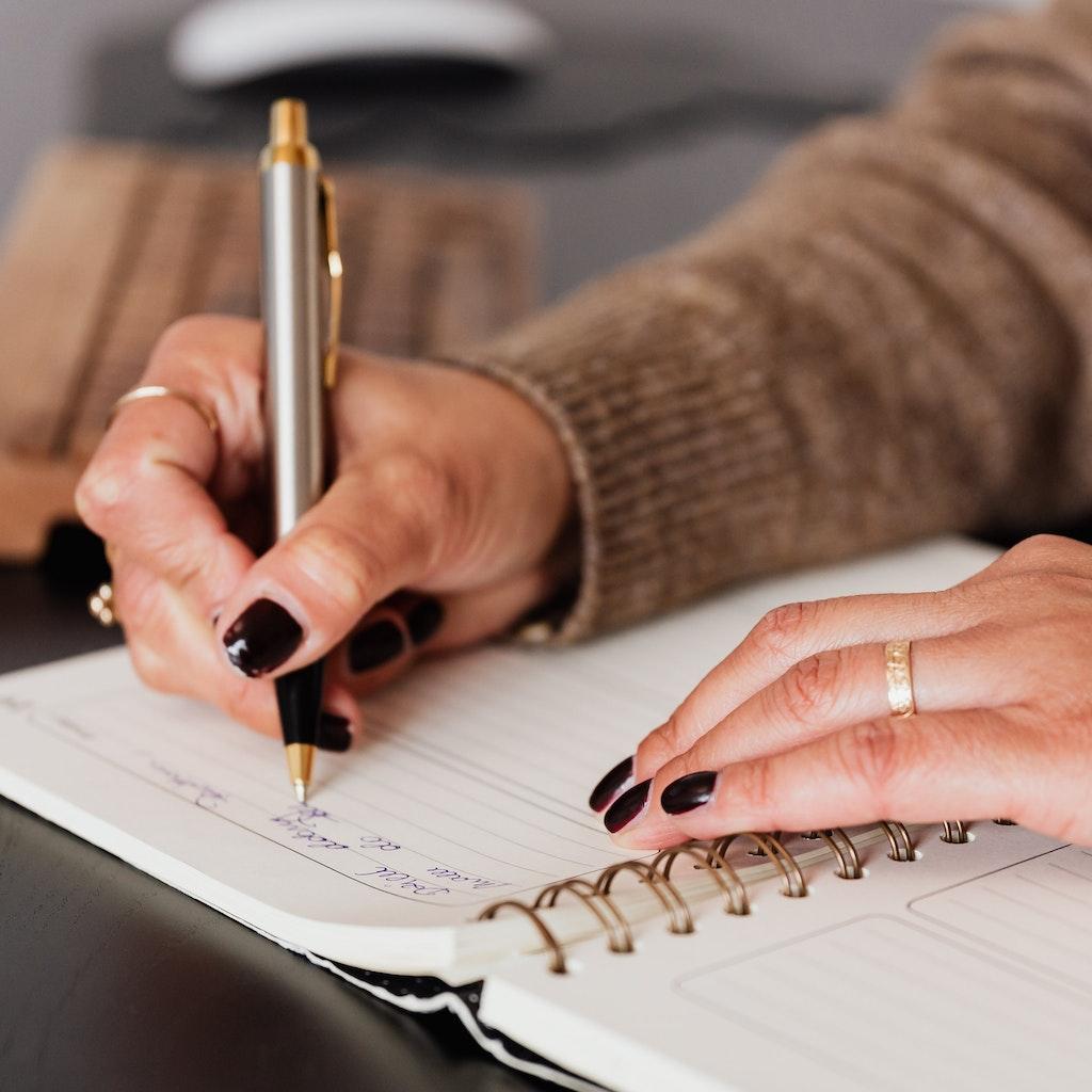 Person crafting Affirmations in a notebook