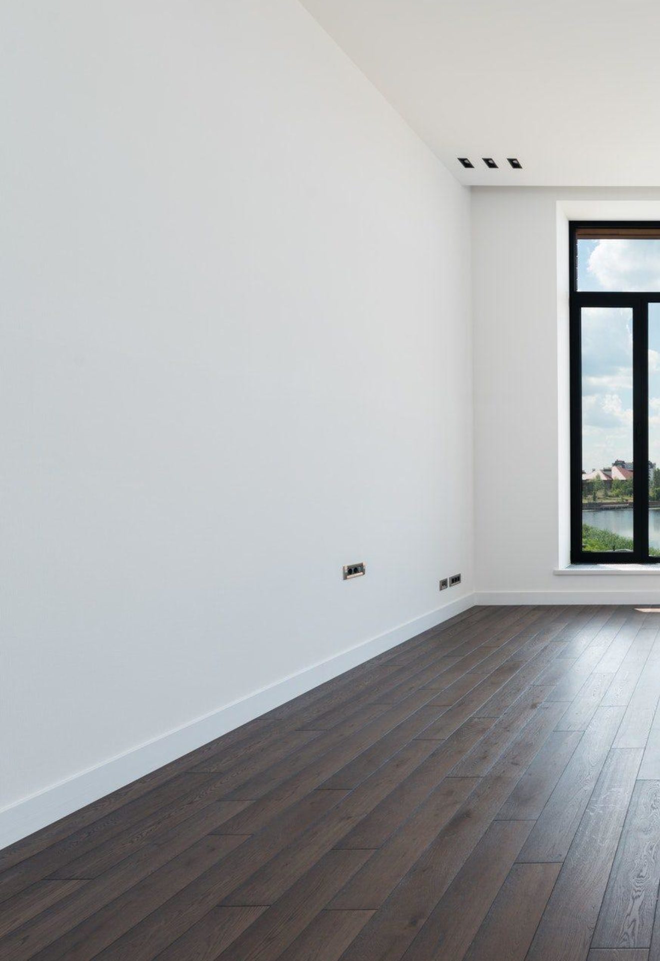 Empty room with clean white walls and a window overlooking a lake