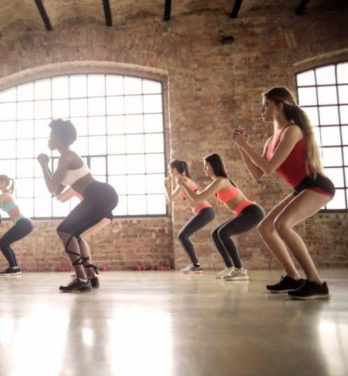 Women squatting doing cardio in a gym studio