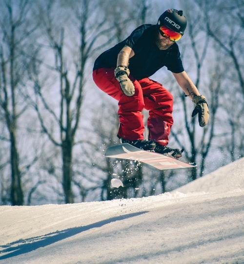 Man Riding on Snowboard In Mid Air Jump