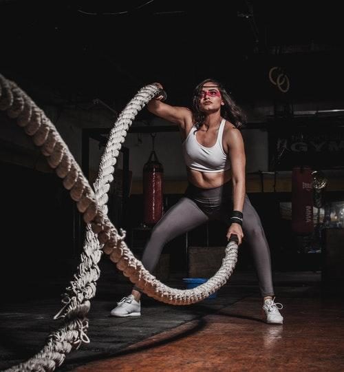 Woman holding battle ropes at the gym