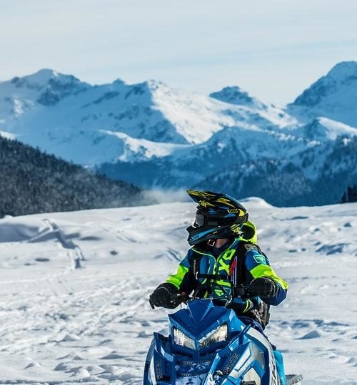 Person Riding a Blue Snowmobile