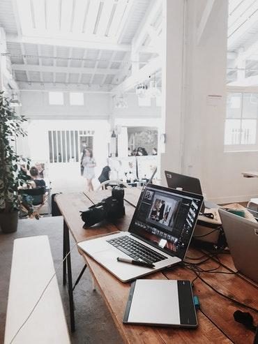 A modern office with laptops on a desk where the employer places emphasis on Work/Life balance, thereby looking after its employees well-being