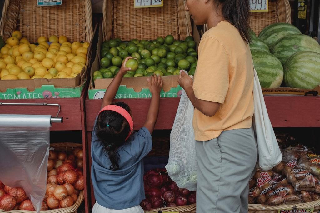 Shoppers choosing food without packaging, supporting sustainable practices to slow climate change.