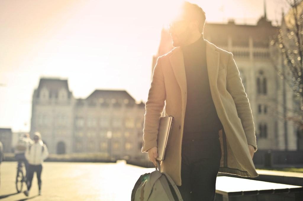 Man walking home from work to support climate change by reducing his carbon emissions.